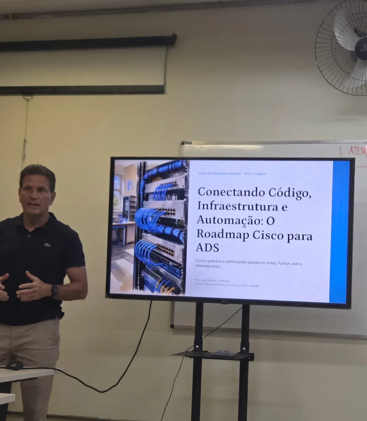 Prof. José Geraldo Moraes presenting Cisco Networking Academy learning tracks at Fatec Taubaté auditorium.